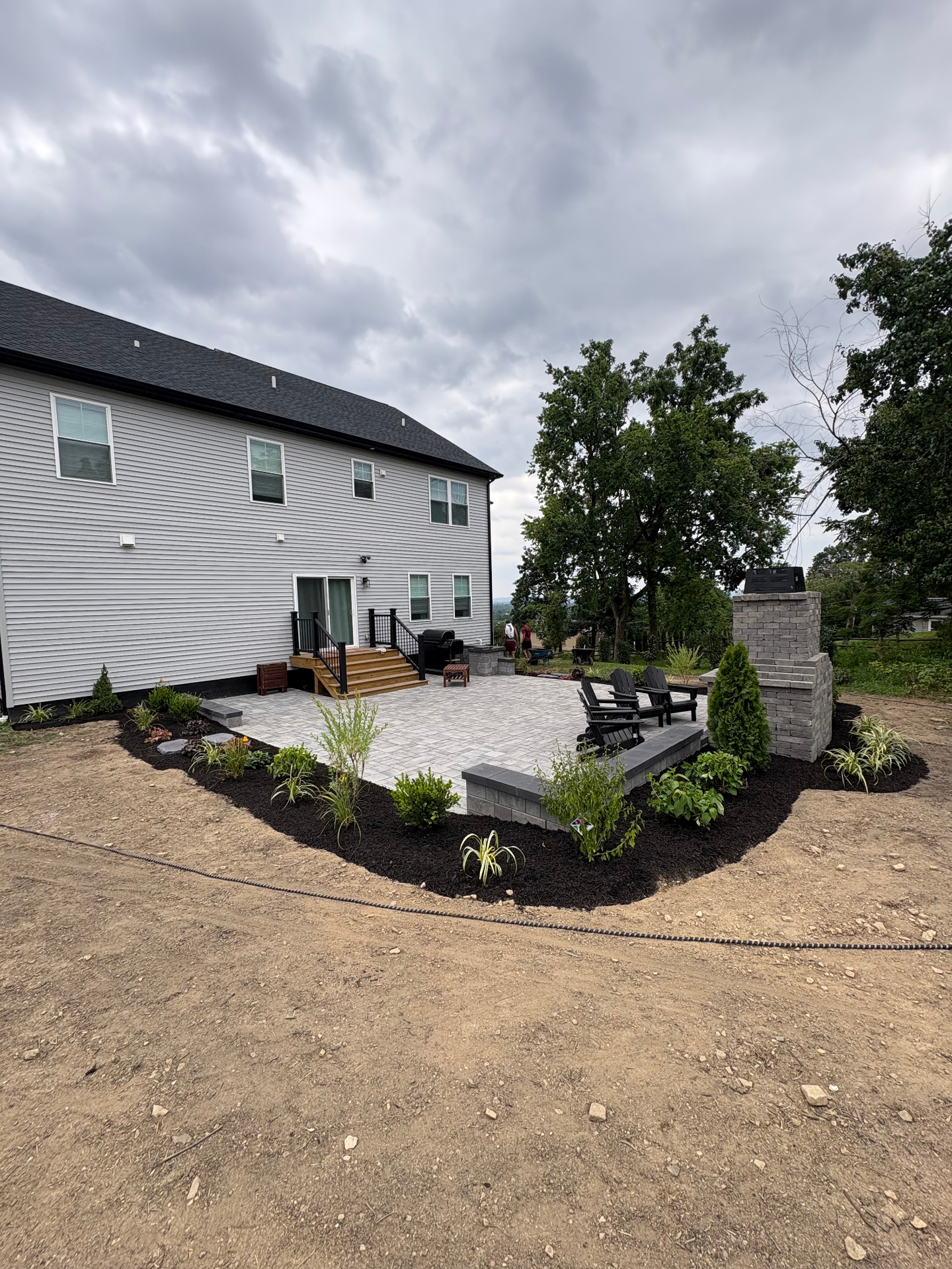 Paver patio with fireplace and fresh planting beds