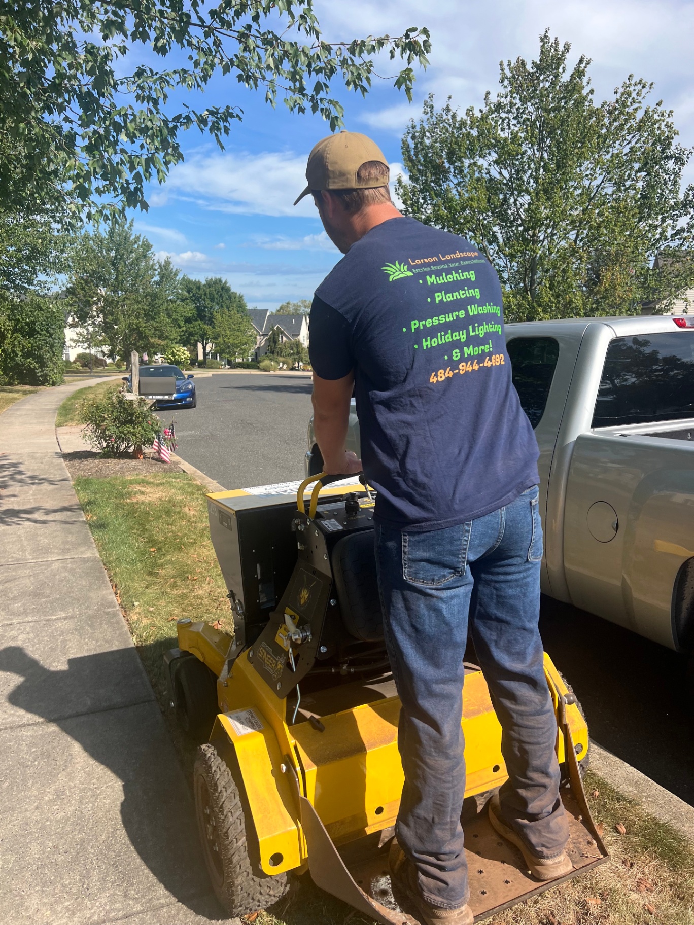 Larson Landscape crew member operating a commercial stand-on aerator
