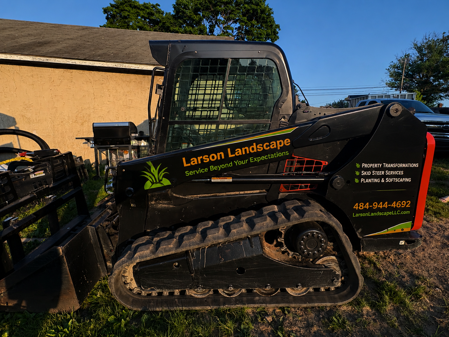 Larson Landscape branded Takeuchi compact track loader parked on the job site