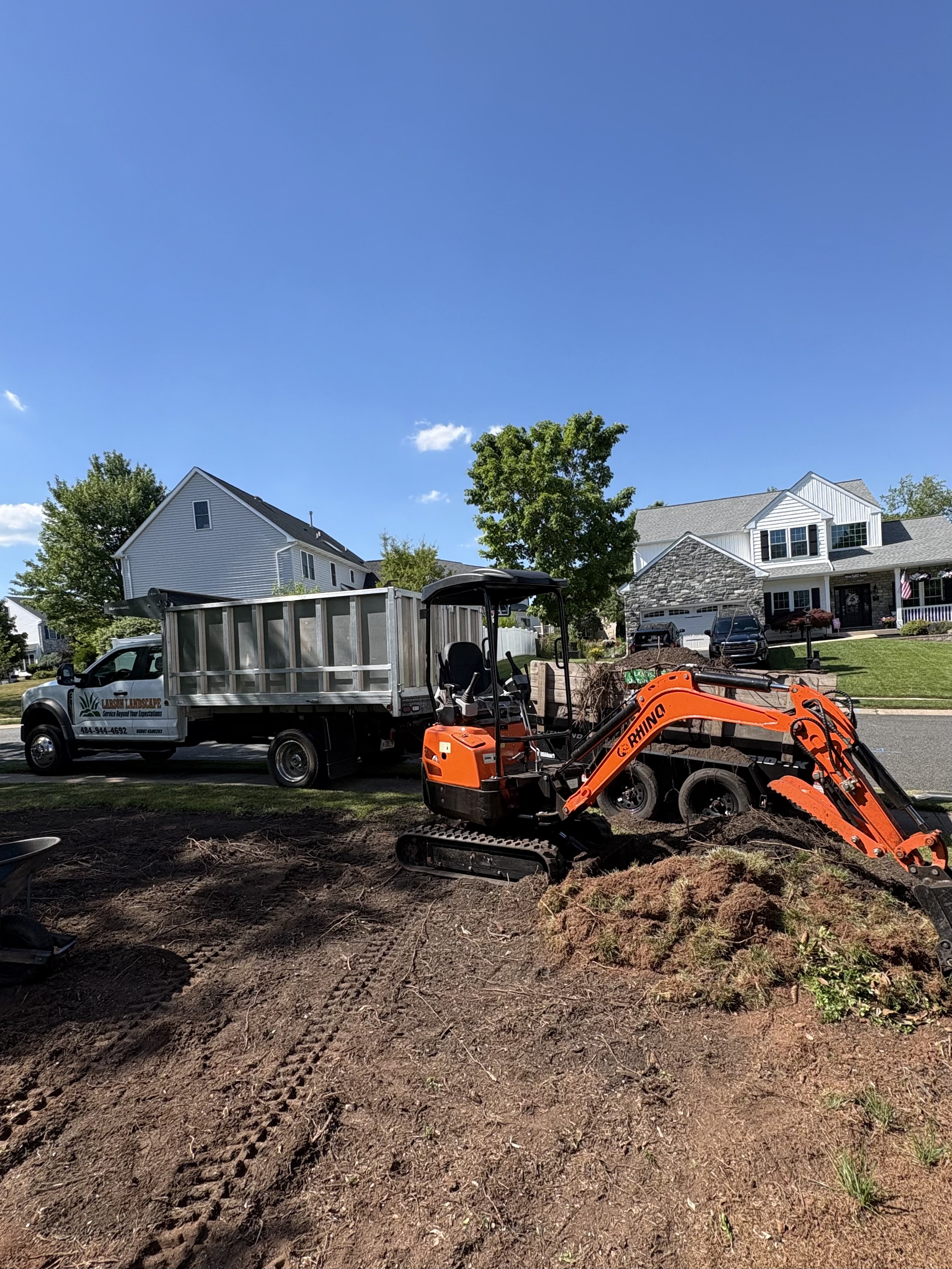 Front porch landscaping with fresh mulch beds, stone edging, and new plantings